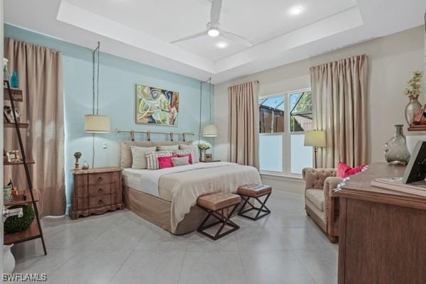 bedroom with a raised ceiling and ceiling fan