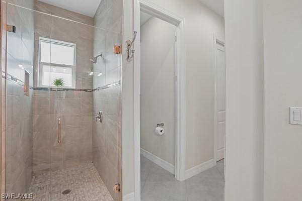 bathroom featuring tile patterned floors, baseboards, and a stall shower