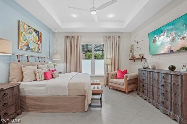 bedroom featuring light tile patterned floors, a raised ceiling, and ceiling fan