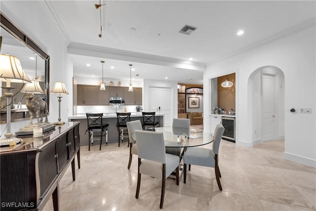 dining space with arched walkways, beverage cooler, visible vents, baseboards, and crown molding