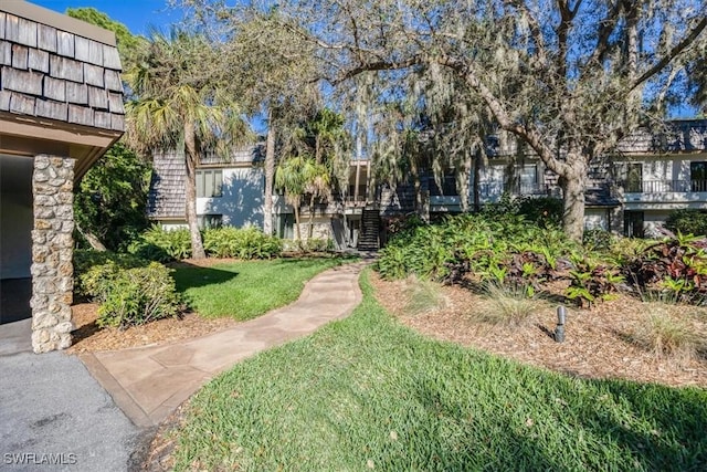 view of property's community featuring stairway and a lawn