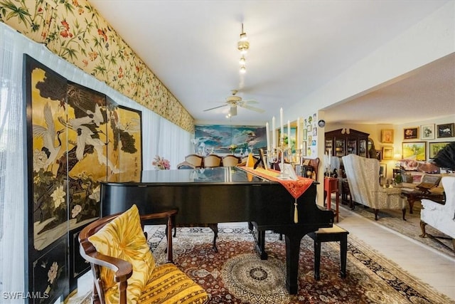 sitting room featuring wallpapered walls, a ceiling fan, and wood finished floors