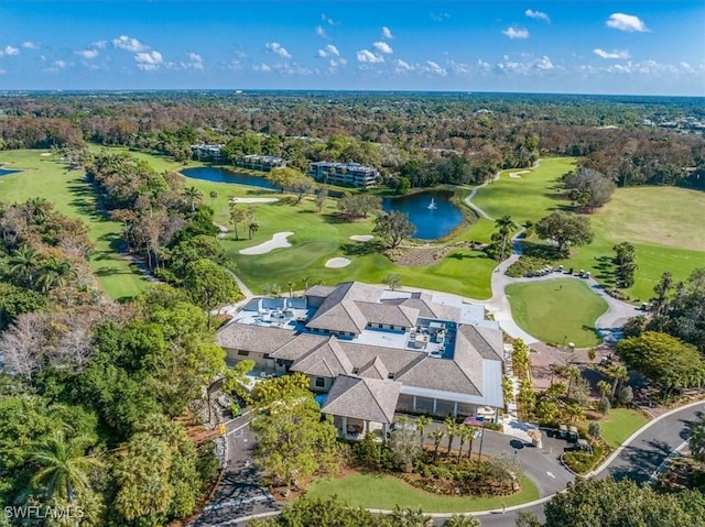 birds eye view of property with a wooded view, golf course view, and a water view