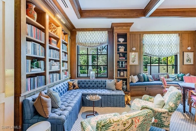 sitting room with built in shelves, wood walls, and ornamental molding