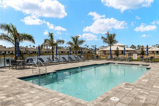 view of pool with a residential view, a patio area, and fence