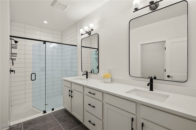 full bathroom featuring visible vents, a sink, a shower stall, and tile patterned floors