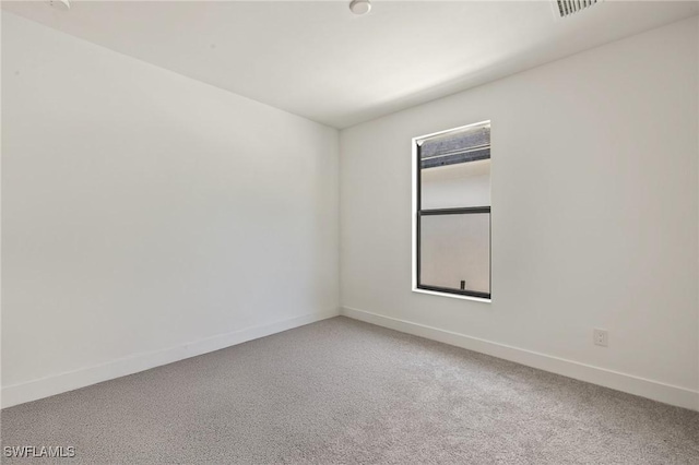 unfurnished room with light carpet, visible vents, and baseboards