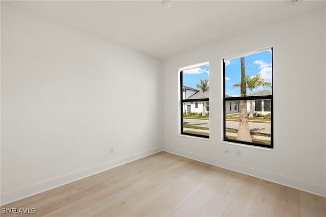 empty room featuring light wood-style flooring and baseboards