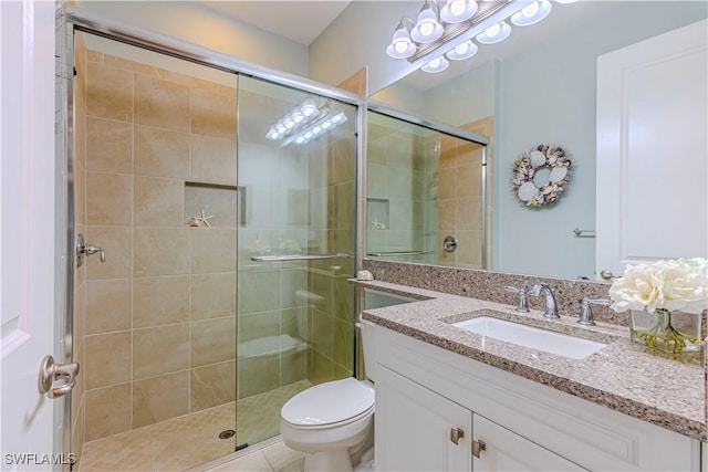 bathroom with toilet, a shower stall, and vanity