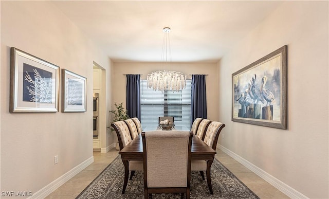 dining space with light tile patterned floors, a chandelier, and baseboards