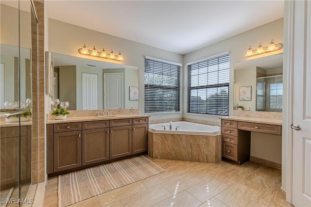 bathroom featuring a garden tub, a shower stall, and vanity