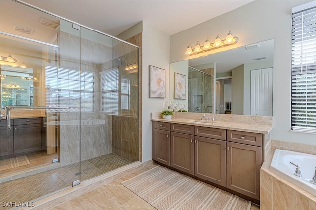 bathroom with vanity, a stall shower, a garden tub, and visible vents