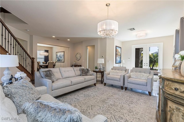 living area featuring french doors, a notable chandelier, recessed lighting, visible vents, and stairs