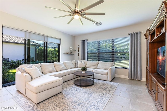 living room with a ceiling fan, visible vents, and baseboards