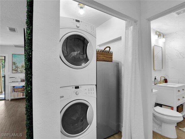 9831 Alabama St Unit 5, Bonita Springs, FL 34135 - washroom featuring hardwood / wood-style flooring, stacked washer and clothes dryer, and sink