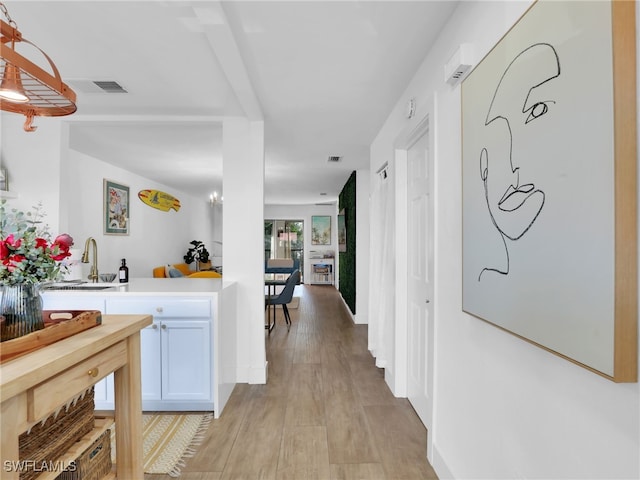 9831 Alabama St Unit 5, Bonita Springs, FL 34135 - corridor featuring sink and light wood-type flooring