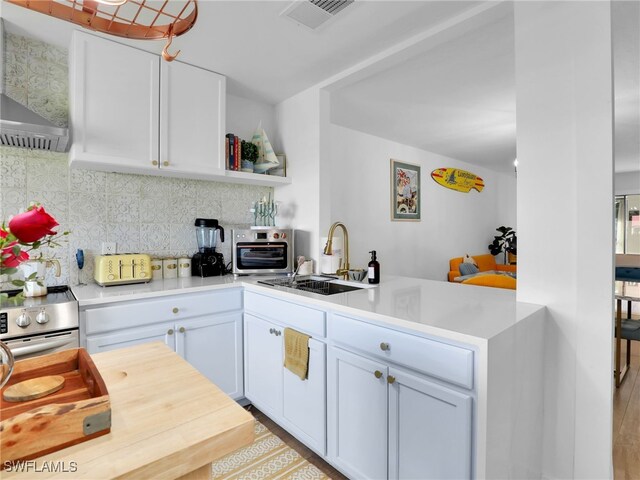 9831 Alabama St Unit 5, Bonita Springs, FL 34135 - kitchen with white cabinetry, sink, decorative backsplash, and kitchen peninsula