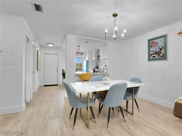 9831 Alabama St Unit 5, Bonita Springs, FL 34135 - dining room with sink, a chandelier, and light hardwood / wood-style flooring