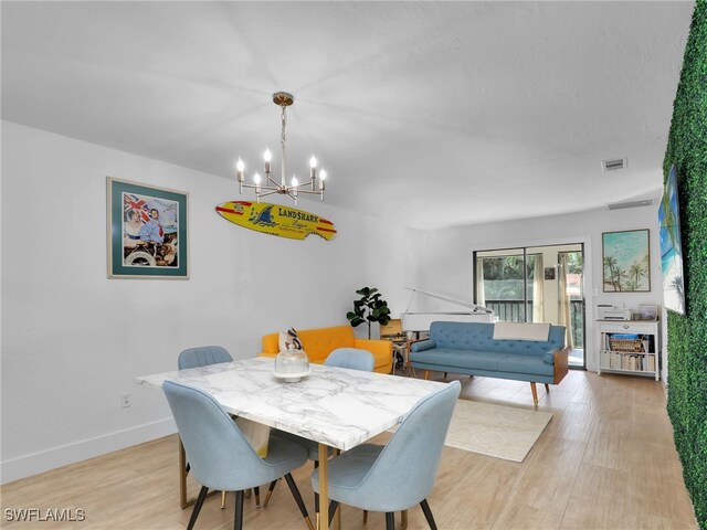 9831 Alabama St Unit 5, Bonita Springs, FL 34135 - dining space with an inviting chandelier and light hardwood / wood-style flooring