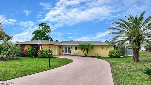 ranch-style home with a front lawn and french doors