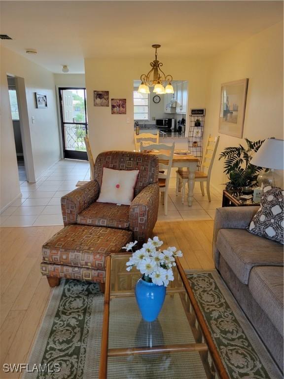 living room featuring a notable chandelier and light hardwood / wood-style flooring