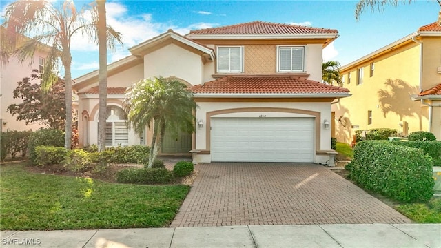 mediterranean / spanish-style home with a garage and a front lawn