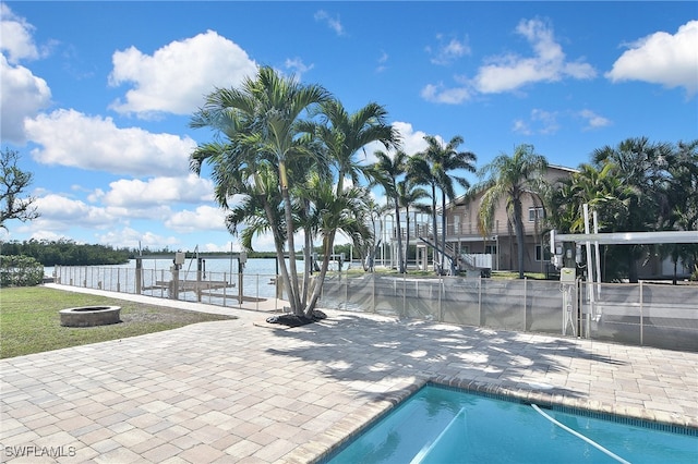 view of pool with a patio and a water view