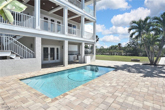 view of pool with area for grilling, a patio area, and a lawn