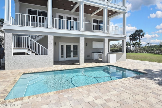 view of swimming pool with exterior kitchen and a patio