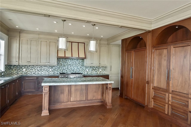 kitchen featuring cream cabinets, a center island, pendant lighting, and light stone counters