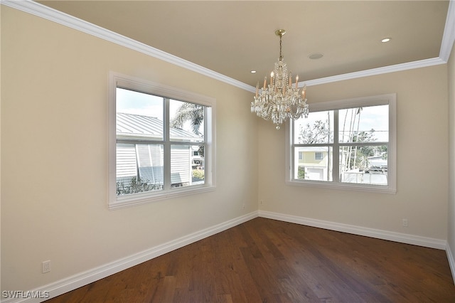 spare room featuring ornamental molding, dark wood-type flooring, and a chandelier