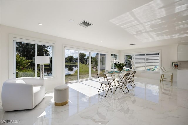 sunroom / solarium featuring a water view