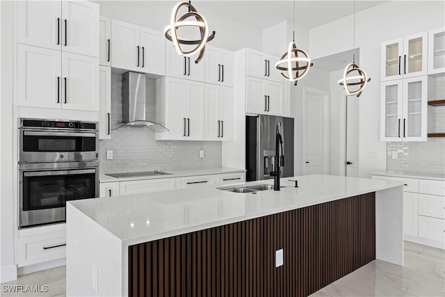 kitchen with pendant lighting, white cabinetry, and wall chimney range hood