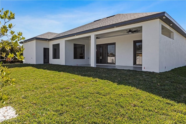 back of house featuring a lawn and ceiling fan