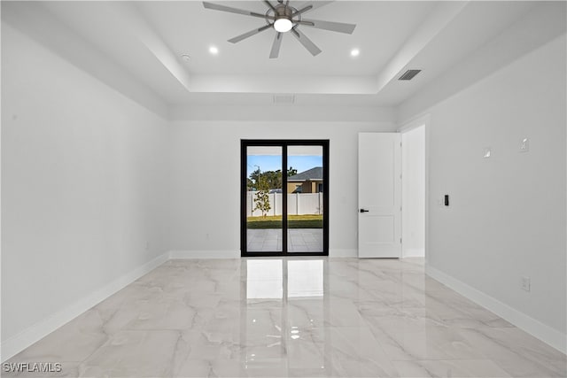 unfurnished room featuring a tray ceiling and ceiling fan