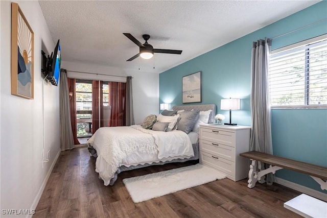 bedroom with ceiling fan, dark wood-type flooring, and a textured ceiling