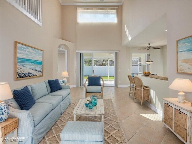 living room featuring light tile patterned floors, a wealth of natural light, ceiling fan, and a high ceiling