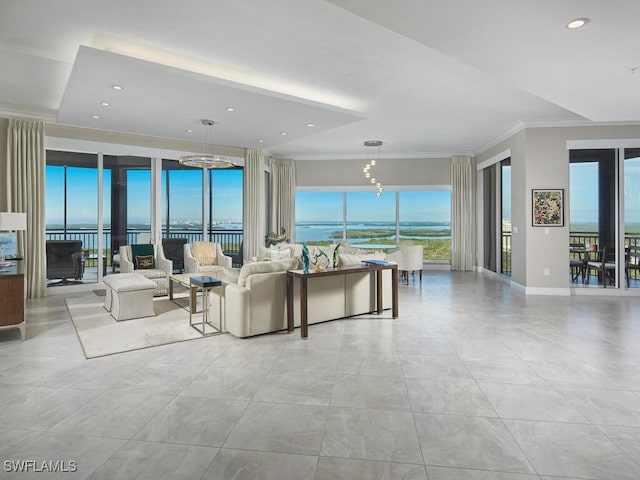 living room featuring an inviting chandelier, crown molding, and a water view