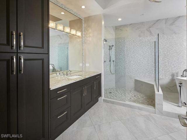 bathroom featuring a tile shower, vanity, and tile patterned flooring