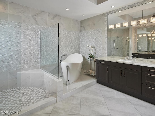 bathroom with tile walls, vanity, and shower with separate bathtub