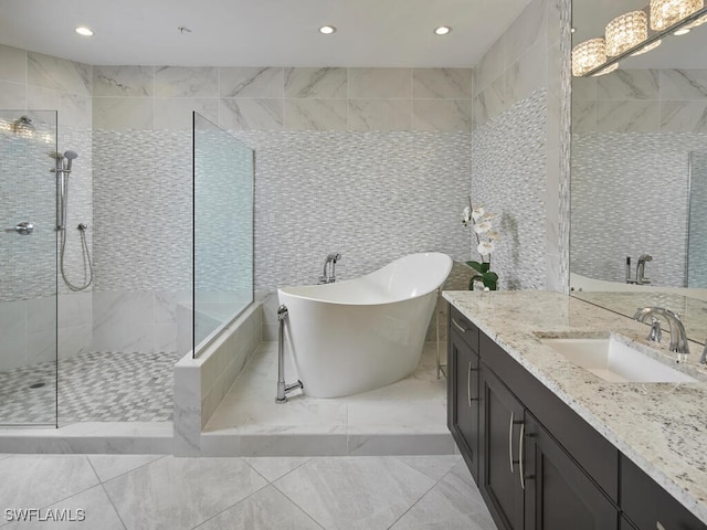 bathroom with vanity, tile walls, and separate shower and tub