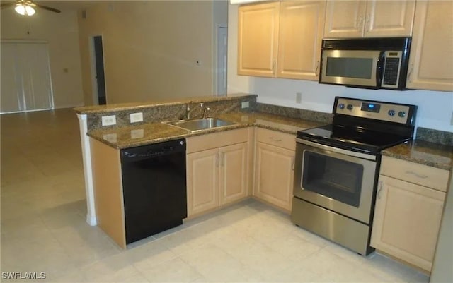 kitchen featuring stainless steel appliances, sink, dark stone countertops, and kitchen peninsula