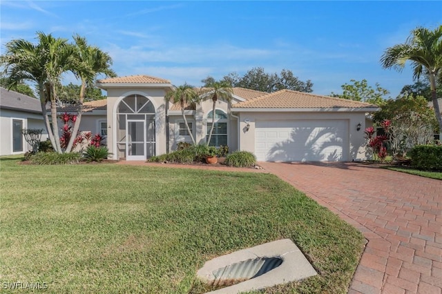 mediterranean / spanish house featuring a garage and a front lawn