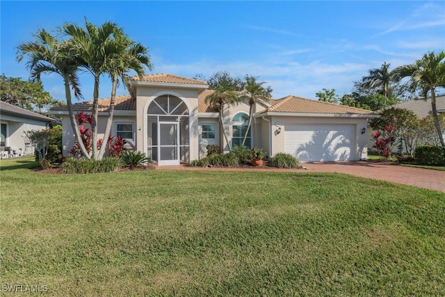 mediterranean / spanish house with a garage and a front lawn