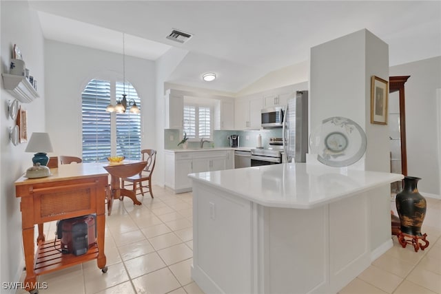 kitchen featuring pendant lighting, white cabinetry, an inviting chandelier, stainless steel appliances, and kitchen peninsula