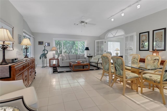 tiled living room featuring ceiling fan, track lighting, and vaulted ceiling