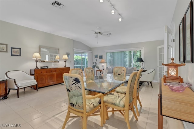 dining area with lofted ceiling, light tile patterned floors, track lighting, and ceiling fan