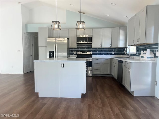 kitchen featuring sink, gray cabinets, appliances with stainless steel finishes, hanging light fixtures, and a center island