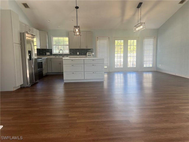 kitchen featuring hanging light fixtures, appliances with stainless steel finishes, sink, and decorative backsplash