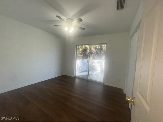 spare room with dark wood-type flooring and ceiling fan